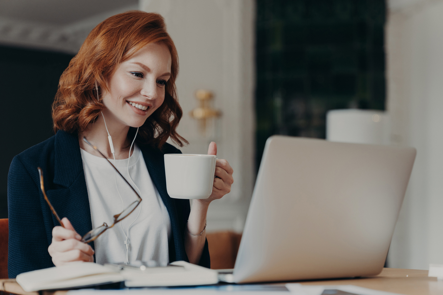 Mujer aprendiendo en línea con un computador y un cuaderno