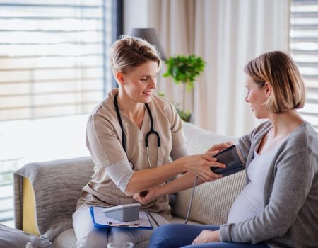 a-healthcare-worker-examining-pregnant-woman-indoors-at-home-.jpg